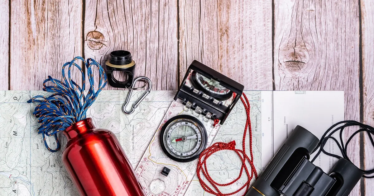Equipamento de sobrevivência e material de emergência organizado sobre mesa de madeira para preparar um kit de 72 horas
