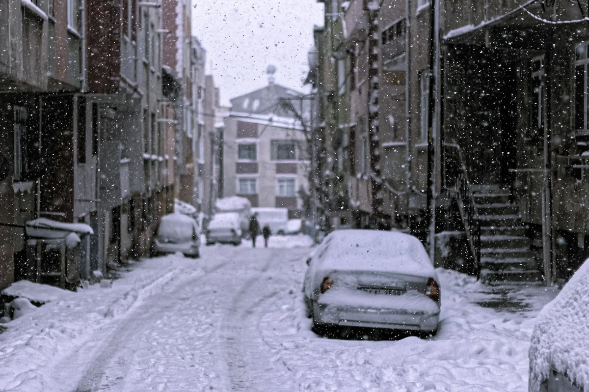 Rua com neve e carros durante nevão extremo